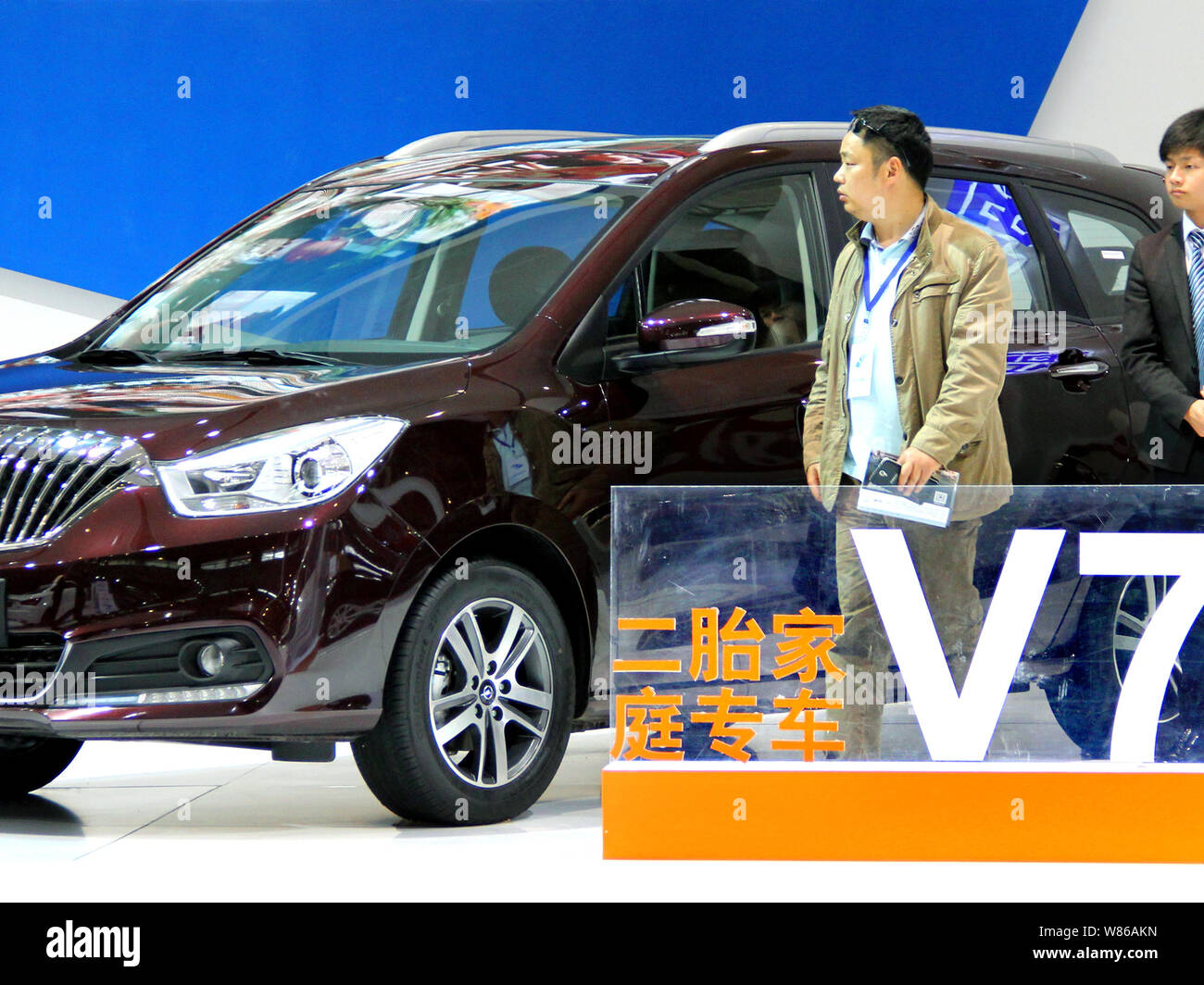 --FILE--A Chinese visitor looks at a car on display during an auto show in Nanjing city, east China's Jiangsu province, 29 April 2016.   Passenger veh Stock Photo