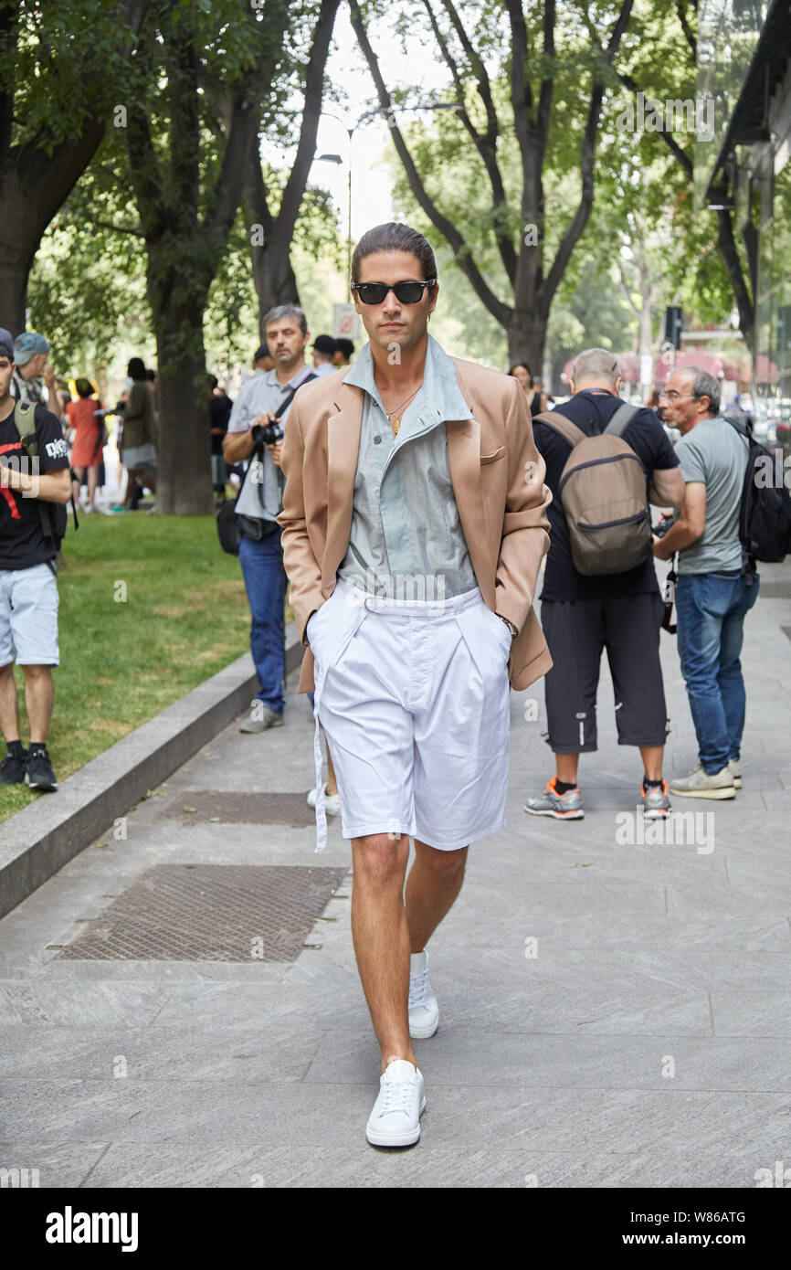 MILAN ITALY JUNE 15 2019 Man walking with white short trousers and beige jacket before Emporio Armani fashion show Milan Fashion Week street sty Stock Photo Alamy