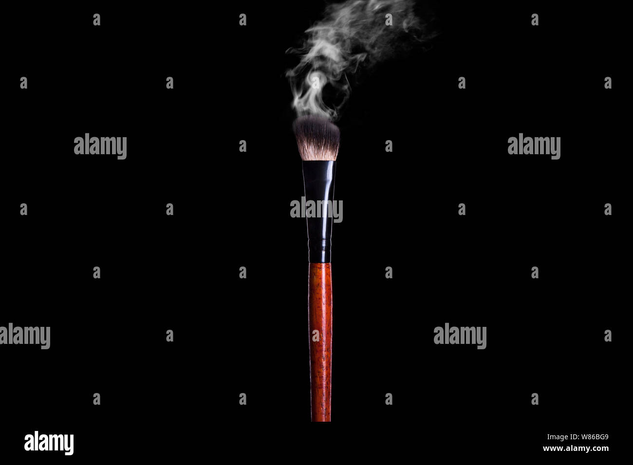 Steaming wooden brush for makeup and cosmetics on a black background. Stock Photo