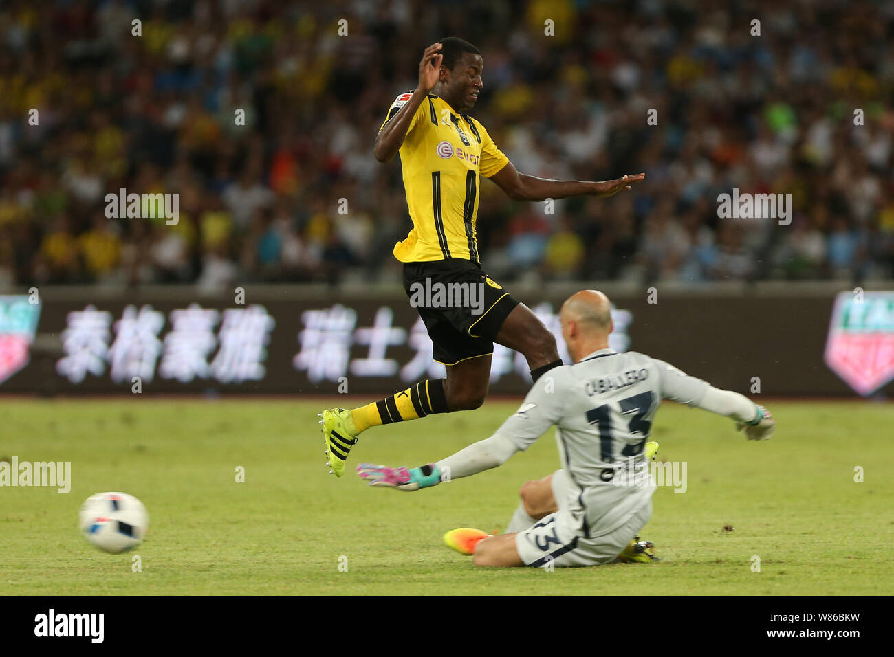 Adrian Ramos of Borussia Dortmund, top, jumps over goalkeeper Willy Caballero of Manchester City during the Shenzhen match of the 2016 International C Stock Photo