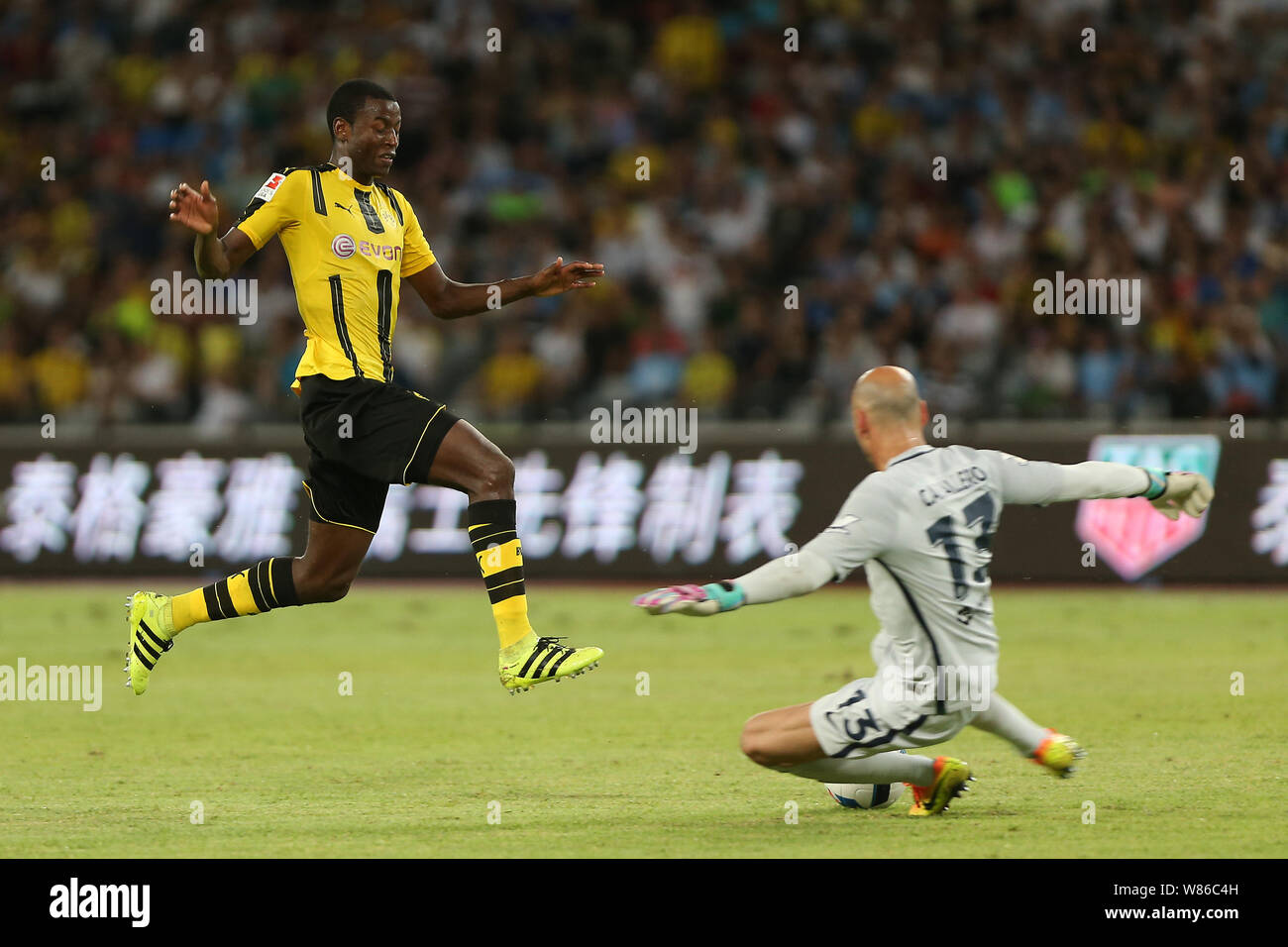 Adrian Ramos of Borussia Dortmund, left, jumps over goalkeeper Willy Caballero of Manchester City during the Shenzhen match of the 2016 International Stock Photo