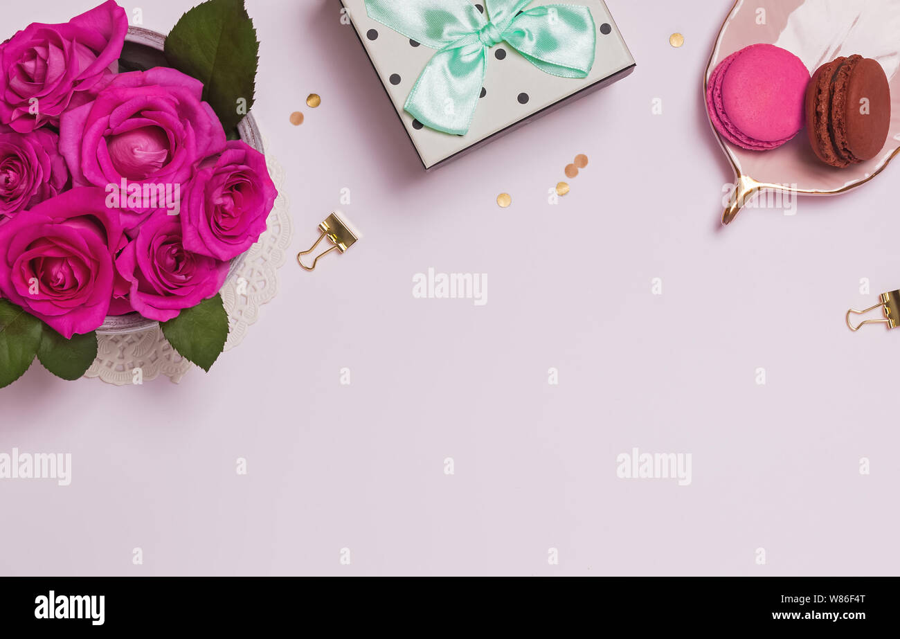 Flat lay with beautiful pink roses, gift box and macarons on white ...