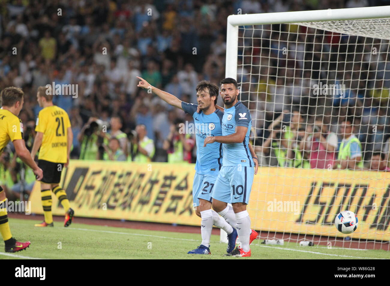 Sergio Aguero of Manchester City, right, celebrates with teammate David Silva after scoring a goal against Borussia Dortmund during the Shenzhen match Stock Photo