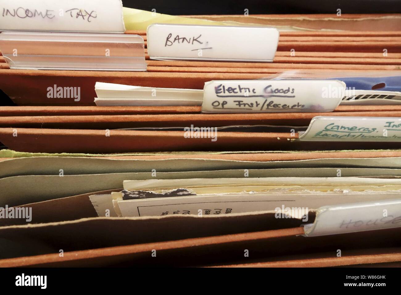 Detail of a filing cabinet with tabs labelled for documents etc Stock Photo