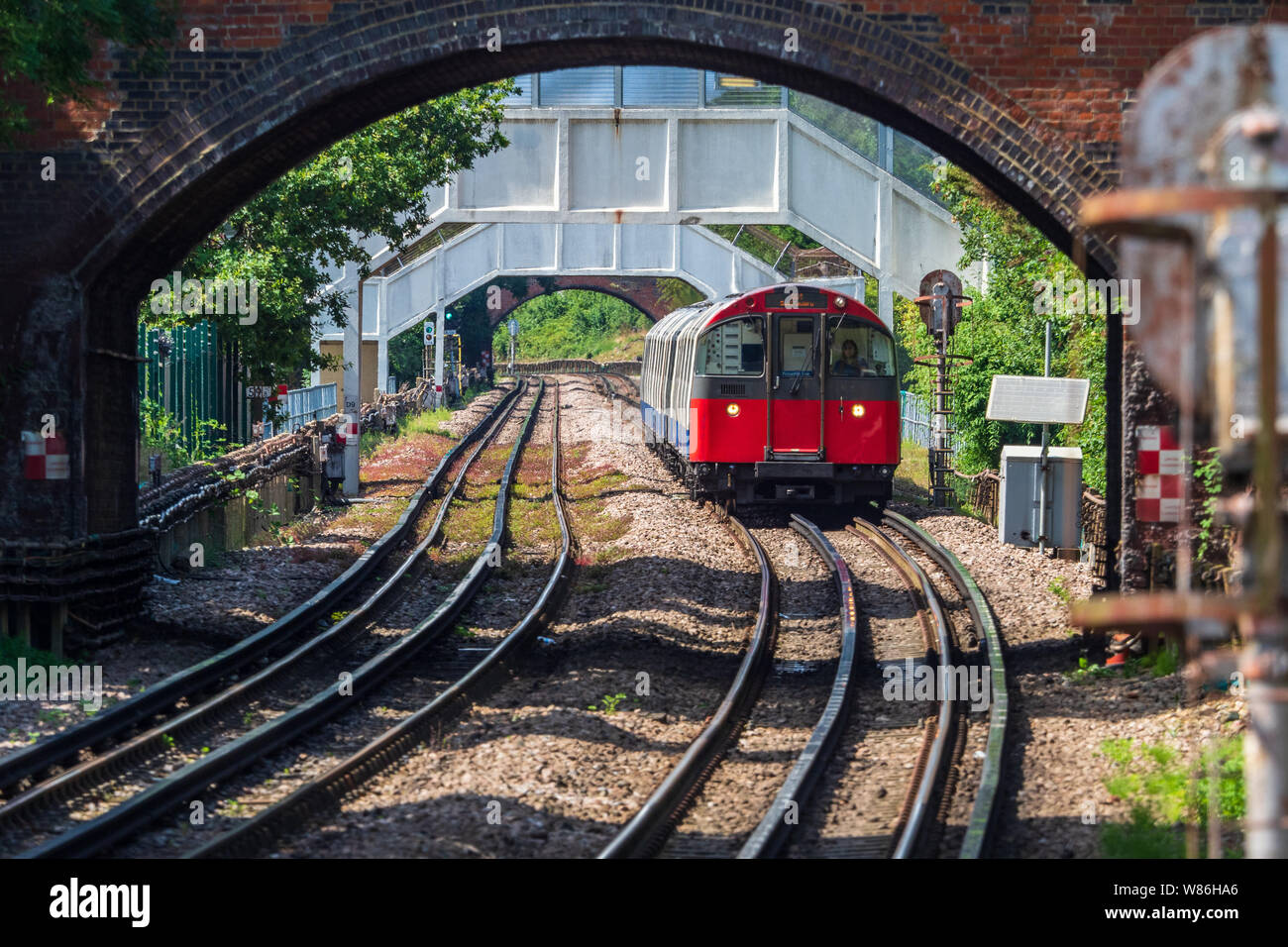 Piccadilly Line Train running overground in West London near Sudbury Town Underground Station Stock Photo