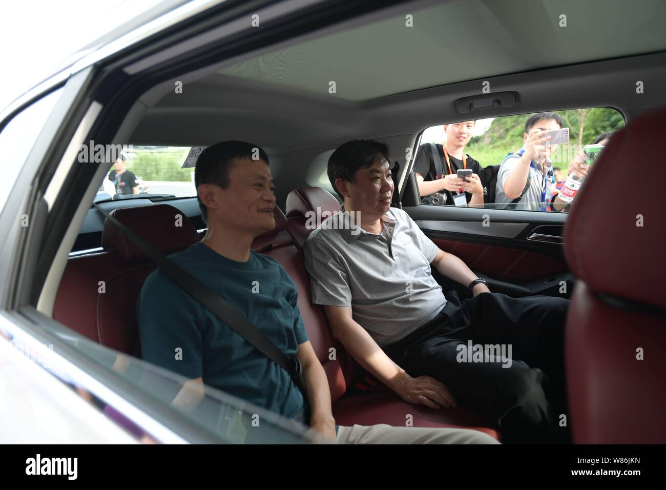 Jack Ma or Ma Yun, left, Chairman of Alibaba Group, and Chen Hong, Chairman  of SAIC Motor, sit in a Roewe RX5 SUV of SAIC Motor featuring Alibaba's Yu  Stock Photo -