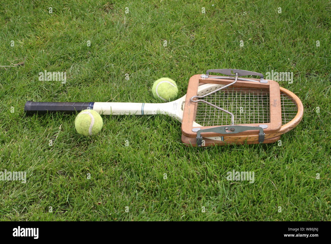Vintage tennis racket and tennis balls on the lawn Stock Photo