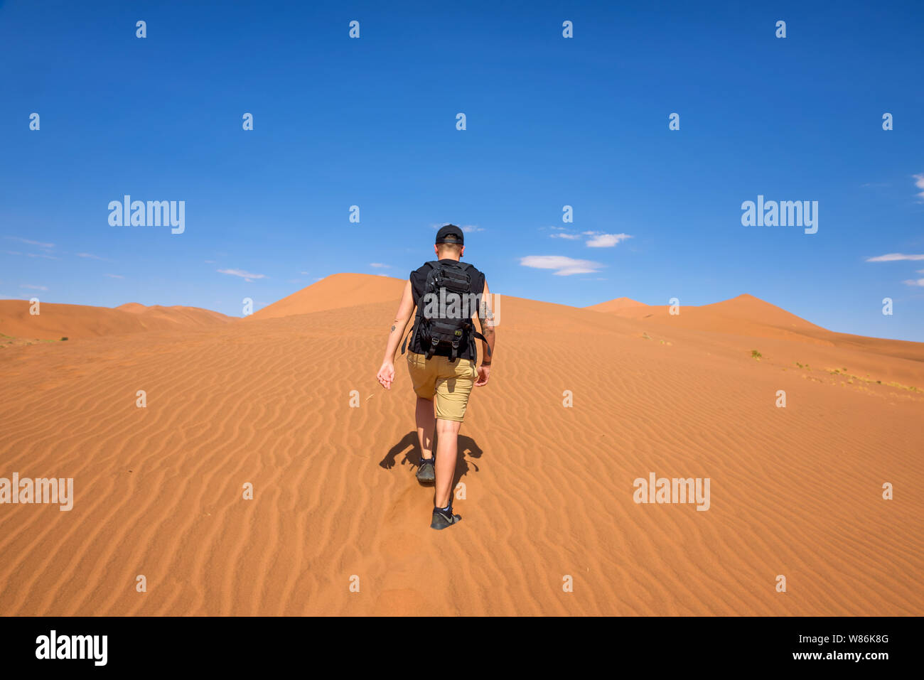 Tourist walks on the scenic dunes of Sossusvlei in the Namib desert, Namibia Stock Photo