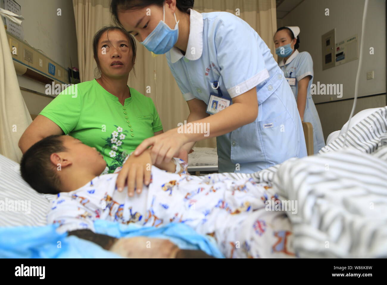 A Chinese nurse examines nine-year-old boy Lei Lei at a hospital after his mother slashed his wrist with a meat cleaver to treat his snake bite in Cho Stock Photo