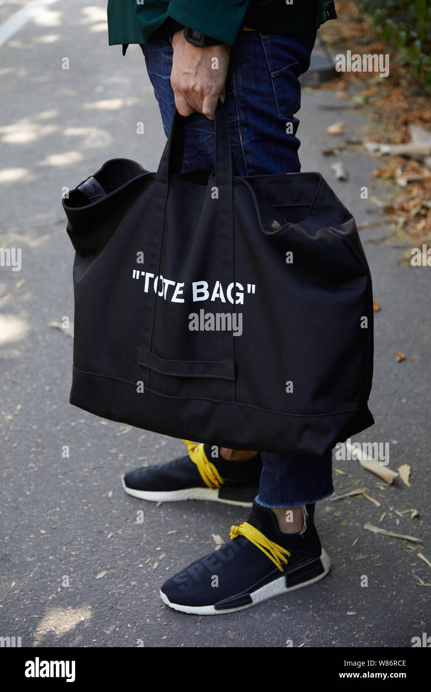 MILAN, ITALY - JUNE 17, 2019: Man with black fabric tote bag and sneakers  with yellow shoelaces before Fendi fashion show, Milan Fashion Week street  s Stock Photo - Alamy