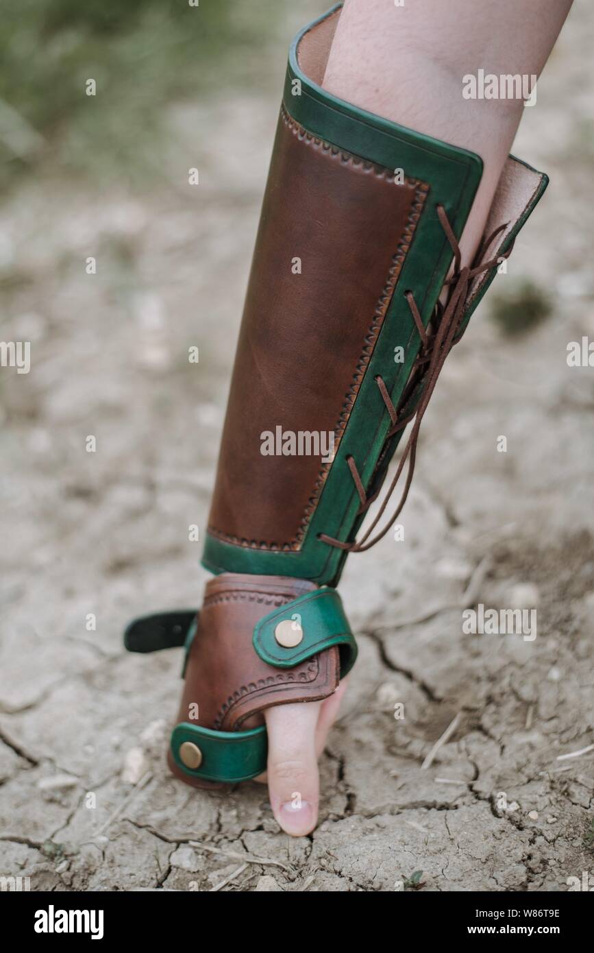 Closeup shot of a person wearing hand armor with the first put on ground Stock Photo