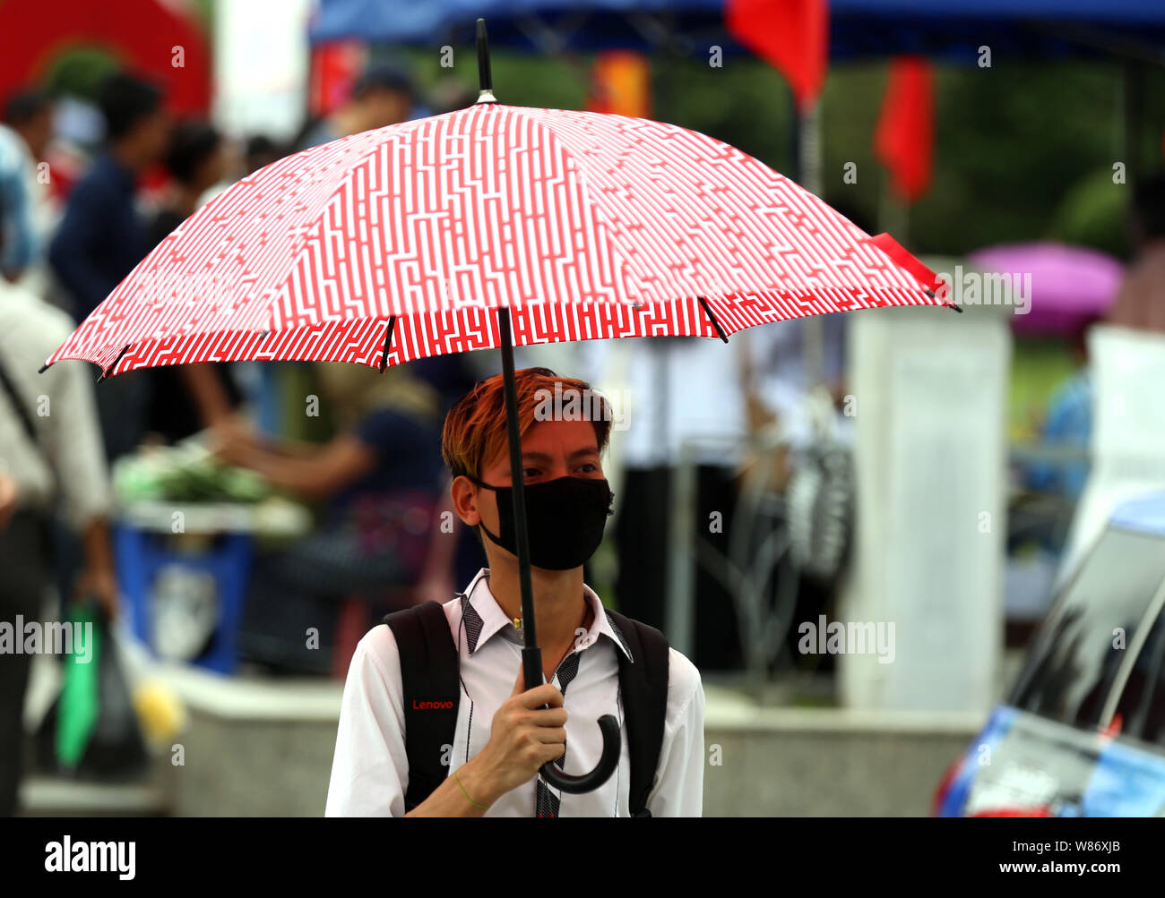 (190808) -- YANGON, Aug. 8, 2019 (Xinhua) -- A man wearing a mask is seen in downtown Yangon, Myanmar, Aug. 8, 2019. Death toll of influenza A (H1N1) pdm09 rose to 90 in Myanmar as of Wednesday, according to the figures released by the Public Health Department under the Ministry of Health and Sports. (Xinhua/U Aung) Stock Photo