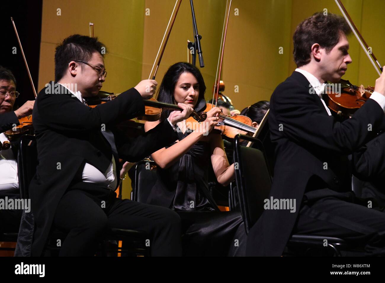 (190808) -- QINGDAO, Aug. 8, 2019 (Xinhua) -- Violinists perform during the Tsingtao International Music Festival at Bluthner (Qingdao) Grand Theatre in Qingdao, east China's Shandong Province, Aug. 7, 2019. Audiences enjoyed several classic eastern and western compositions during the concert. (Xinhua/Li Ziheng) Stock Photo