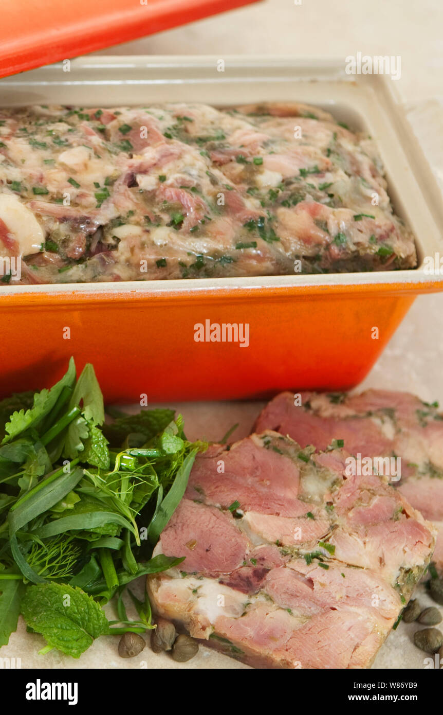 home made ham hock terrine in an orange terrine dish served with