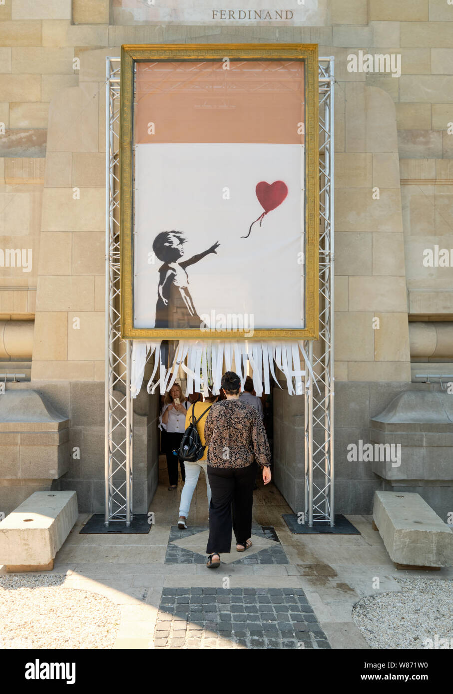Entrance to the Banksy exhibit in Bucharest with image of girl with heart  balloon recreating the shredder effect Stock Photo - Alamy