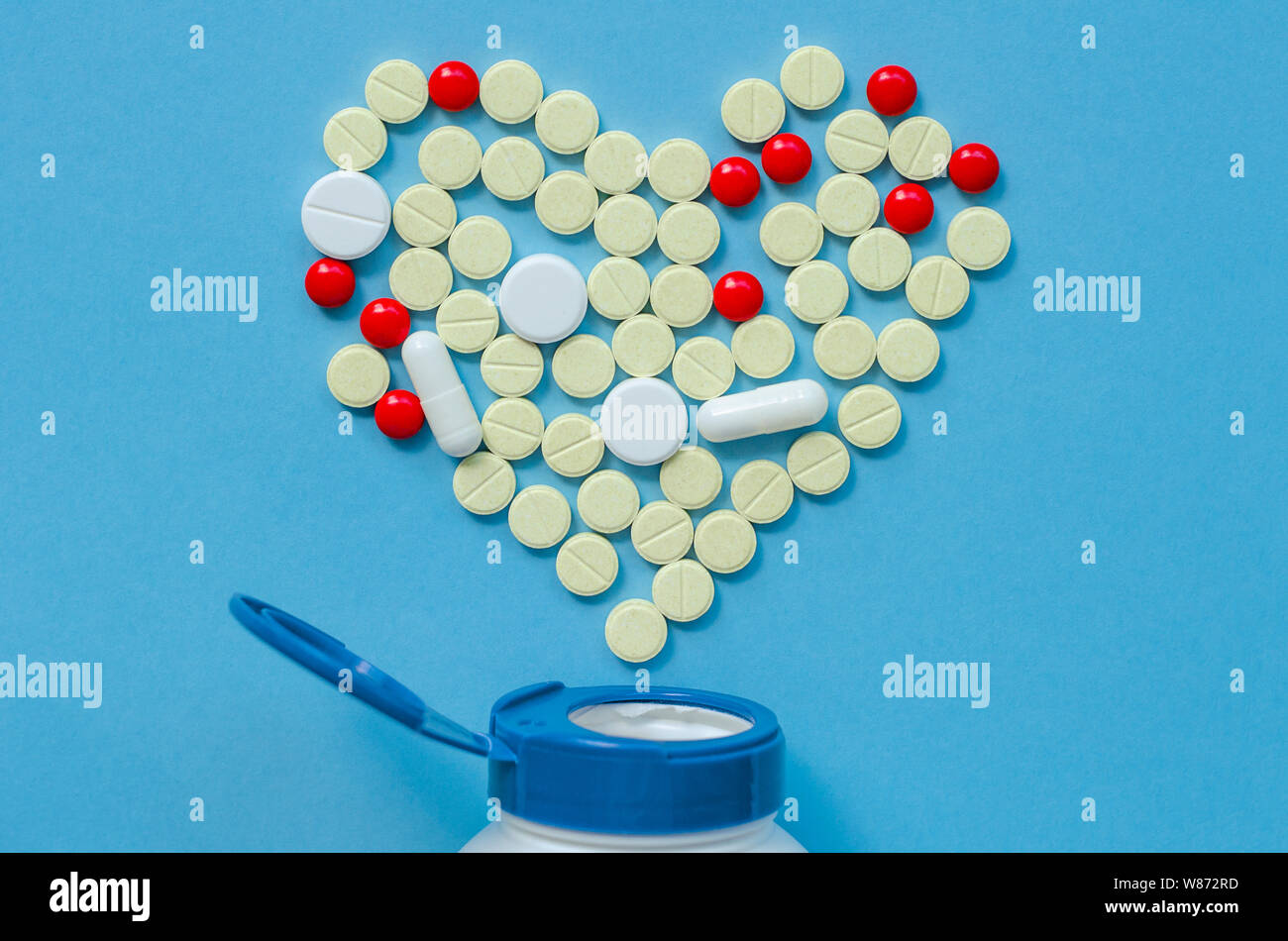 The white heart pills on a colored background. The concept of a healthy