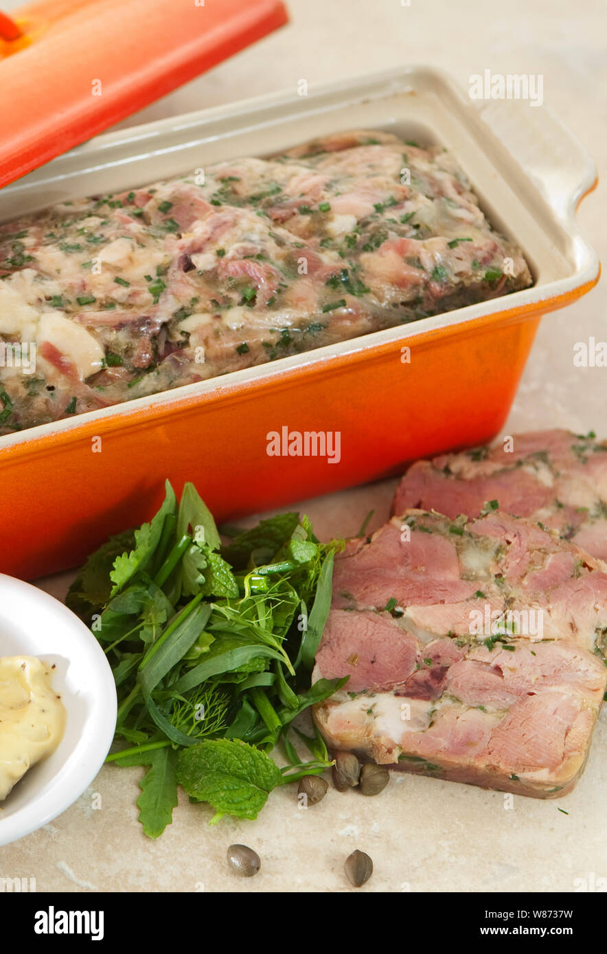 home made ham hock terrine in an orange terrine dish served with