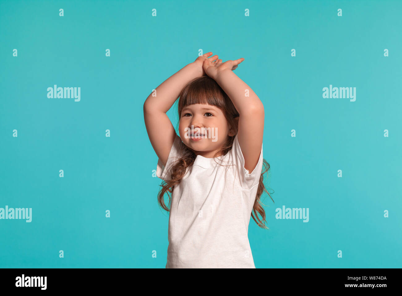 Beautiful little girl wearing in a white t-shirt is posing against a ...