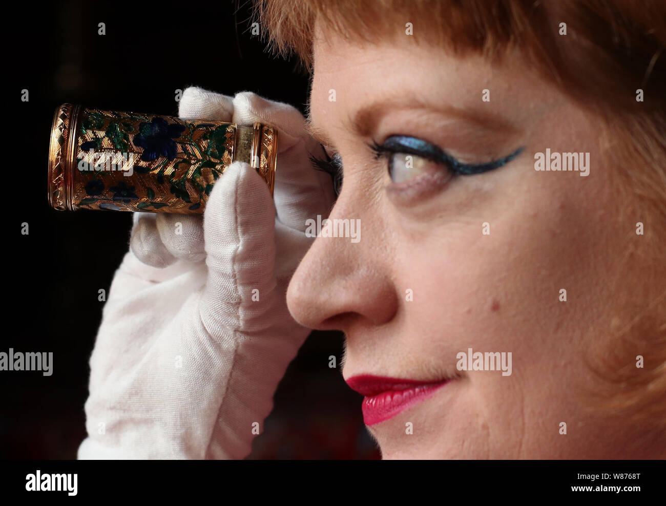 Dr Mia Jackson, Curator of Decorative Arts, looks through an enamelled gold Parisian spyglass (lorgnette), c.1750-1751, at Waddesdon Manor, Buckinghamshire, ahead of the opening of A Rothschild Treasury exhibition, which will be held in a new, permanent, gallery containing more than 300 rarely seen objects spanning two millennia - from a 1st-century cameo of Augustus Caesar's grandson, via jewellery given as presents from Queen Victoria, to objects bearing Nazi inventory numbers. Stock Photo