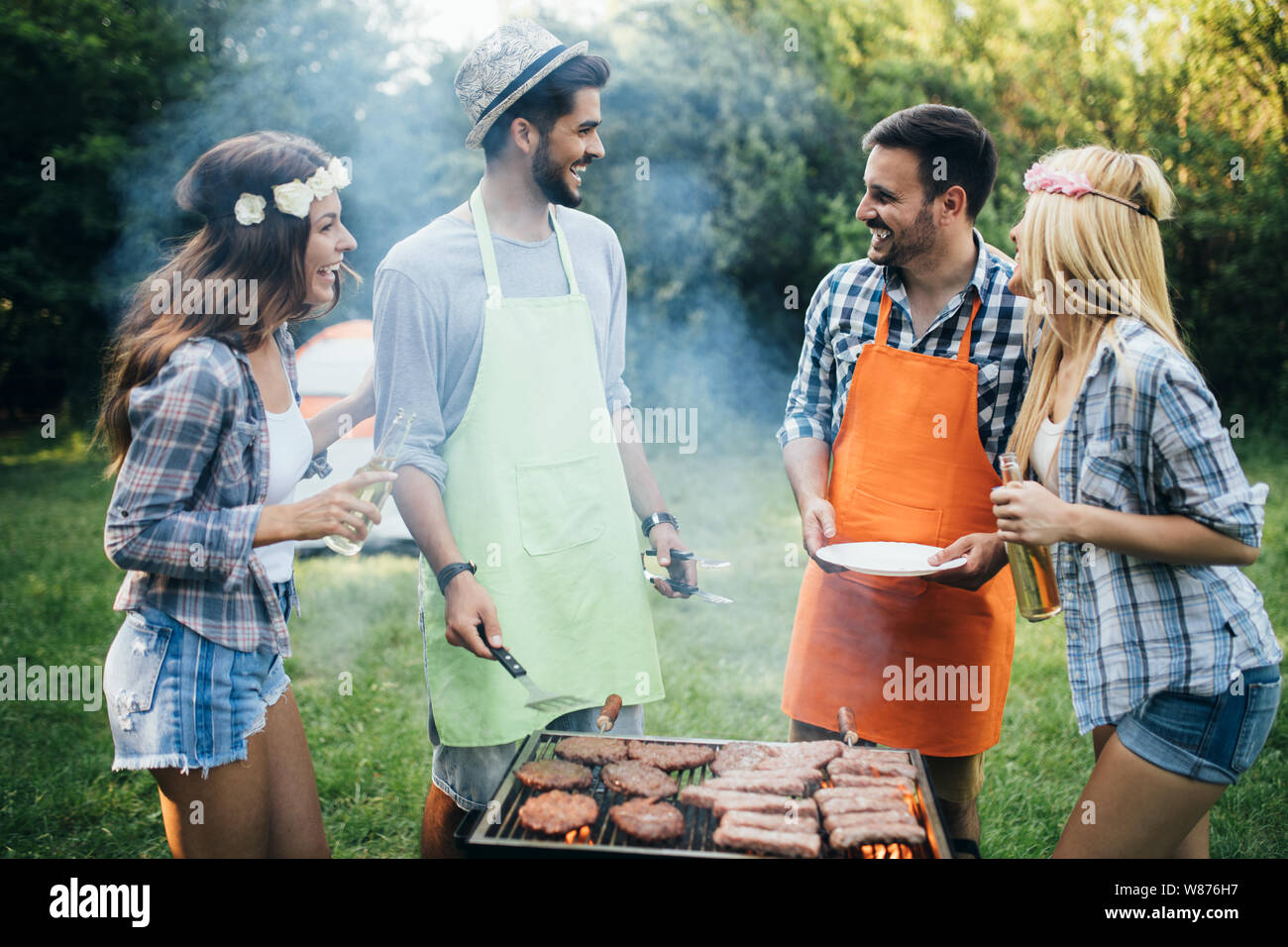 Group of happy friends having barbecue party in forest Stock Photo - Alamy