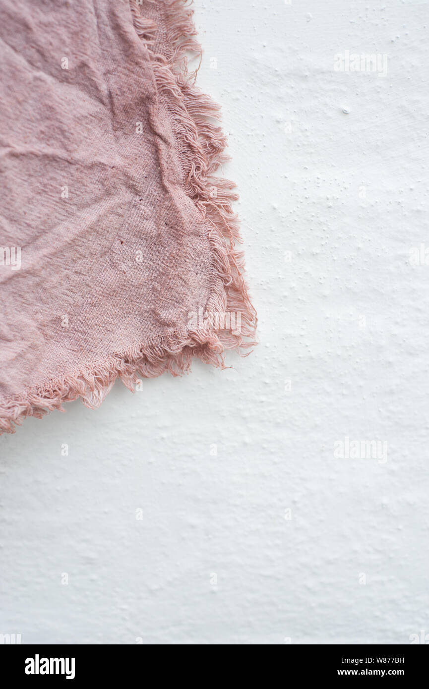 Avocado dyed material on white wall Stock Photo