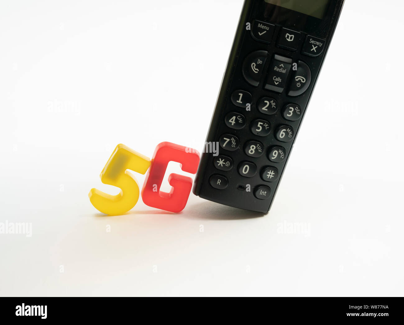 5G telecommunications text letters pushing an old school phone out of the way Stock Photo