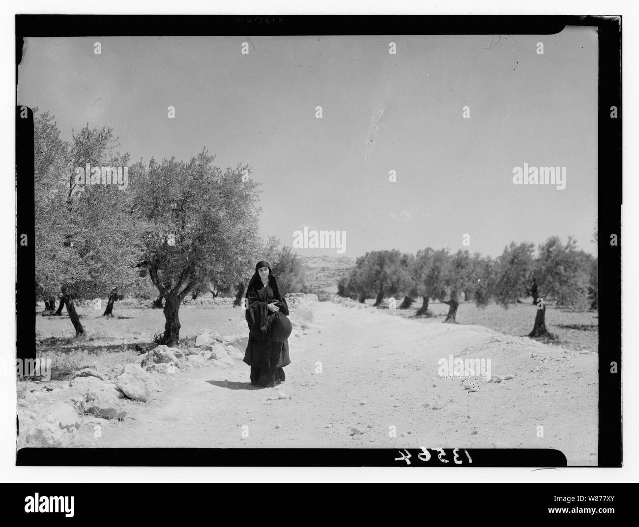Ruth story. Ruth carrying off wheat measured by Boaz (Sirvart). Pathway & trees in background Stock Photo