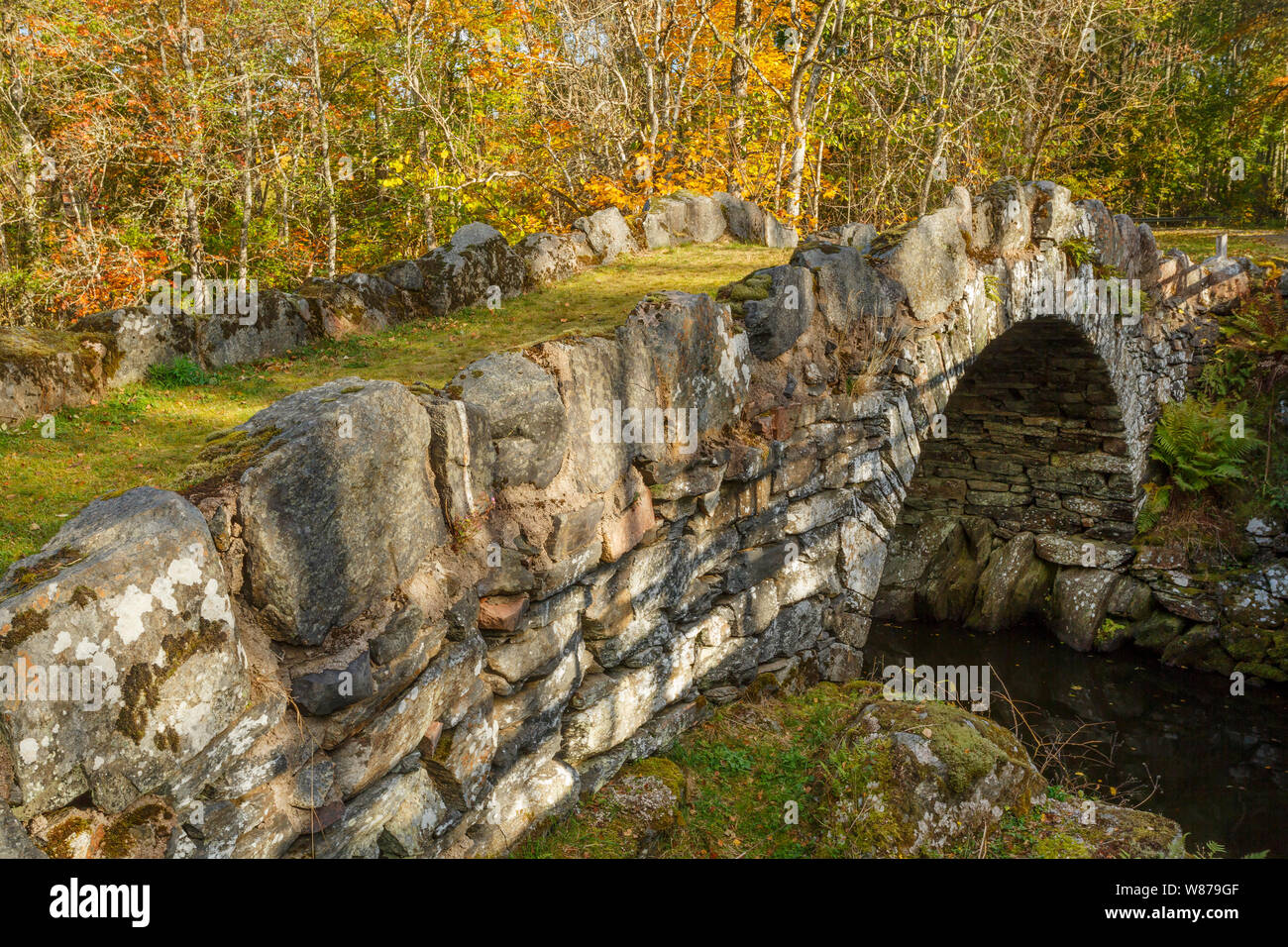Old stone bridge crossing a river with autumn colors in the woods Stock ...