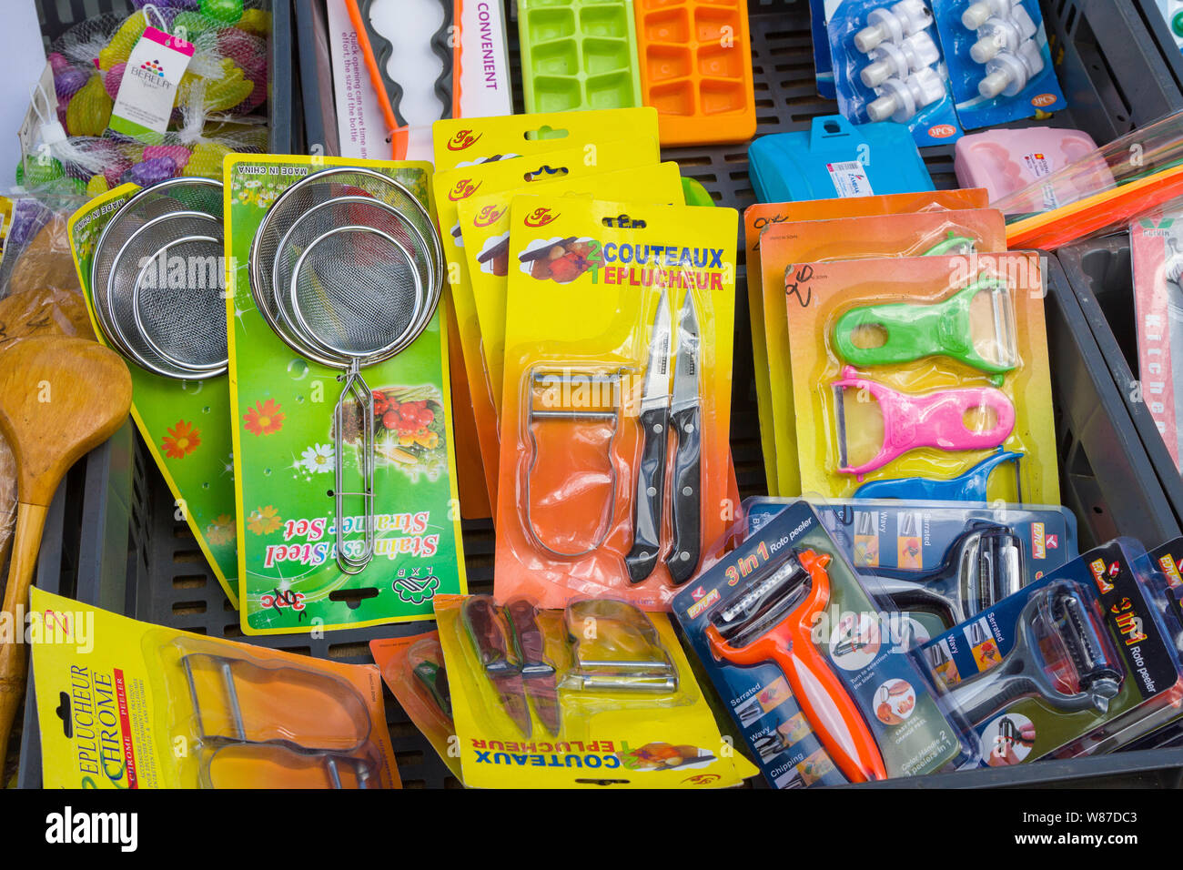 Kitchen utensils in colourful packaging for sale in the Saturday market in Honfleur, Normandy