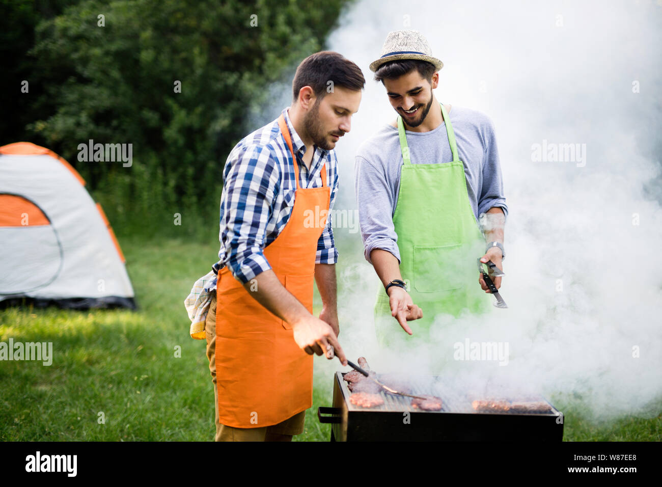 Group of happy friends having barbecue party in forest Stock Photo - Alamy