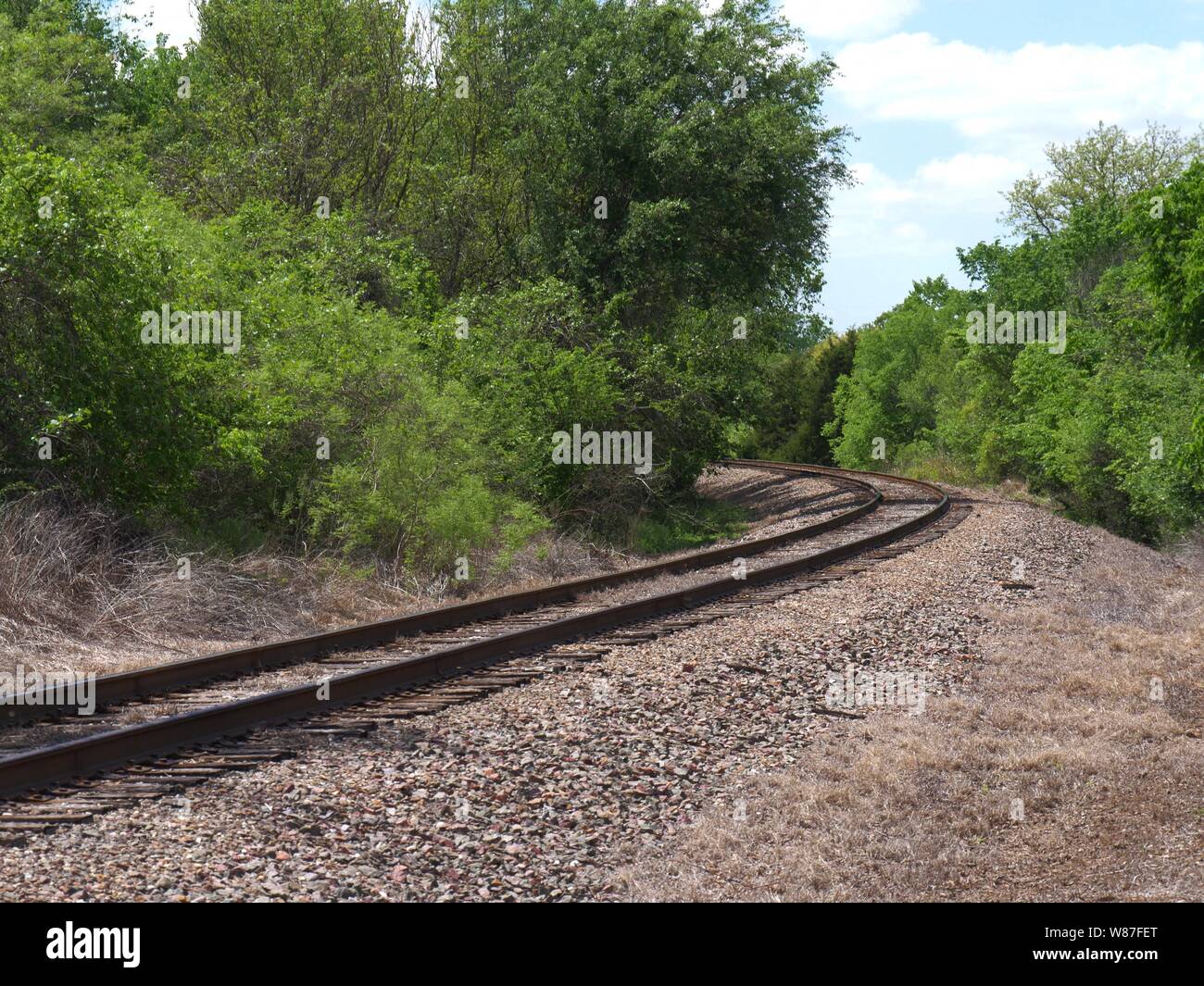 Curving railroad track in the outskirts of a city Stock Photo - Alamy
