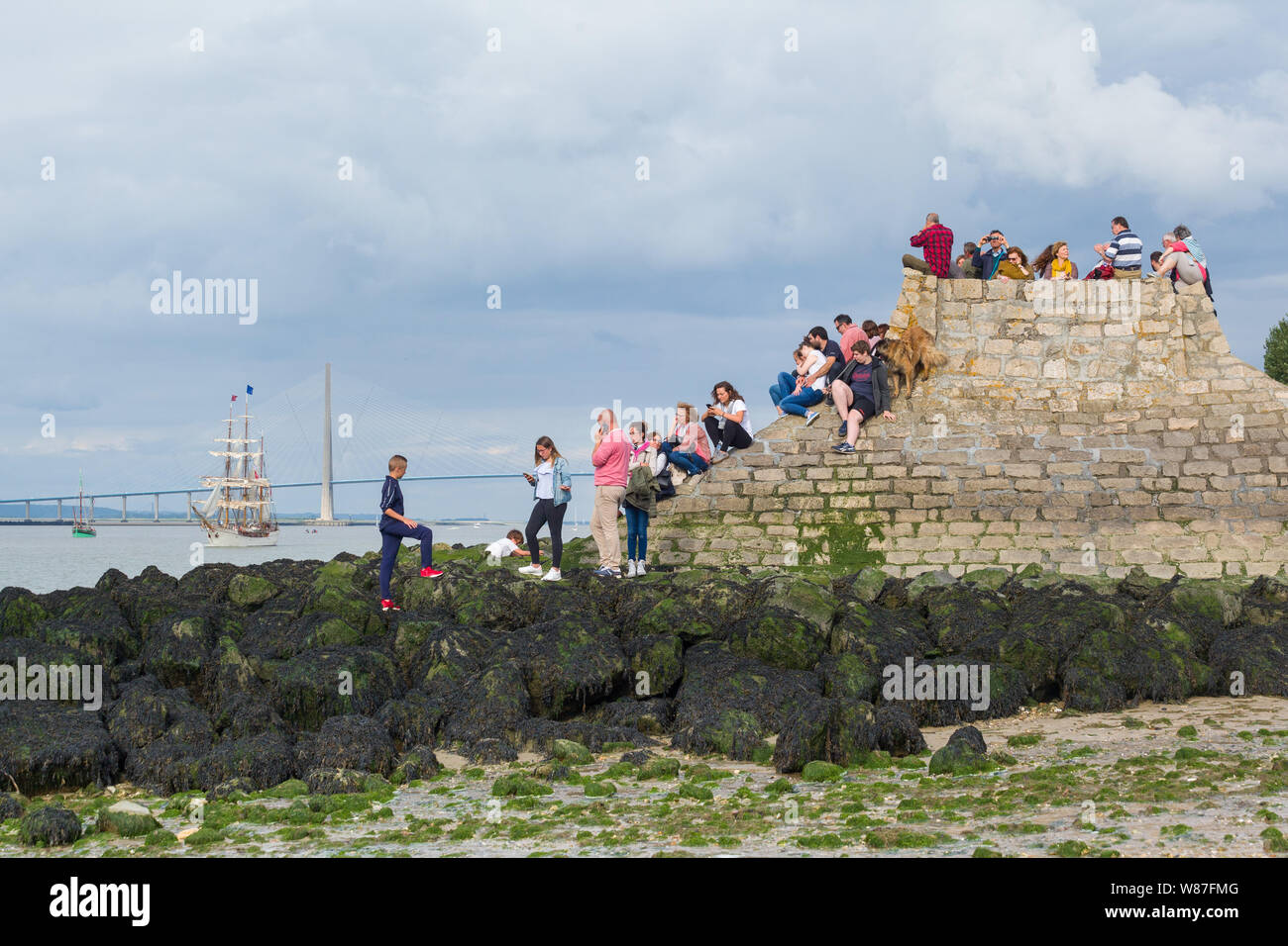 Spectators watch the tall ships returning from the Rouen Armada pass by at Honfleur, Normandy, France Stock Photo