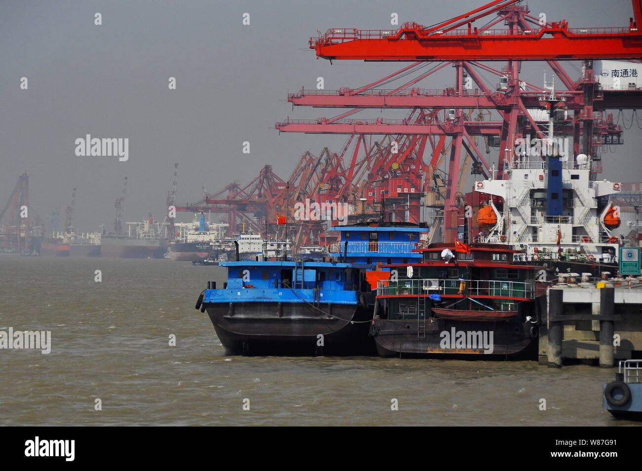 Container ships/boats at the Yangtse river quayside Nantong China Stock Photo
