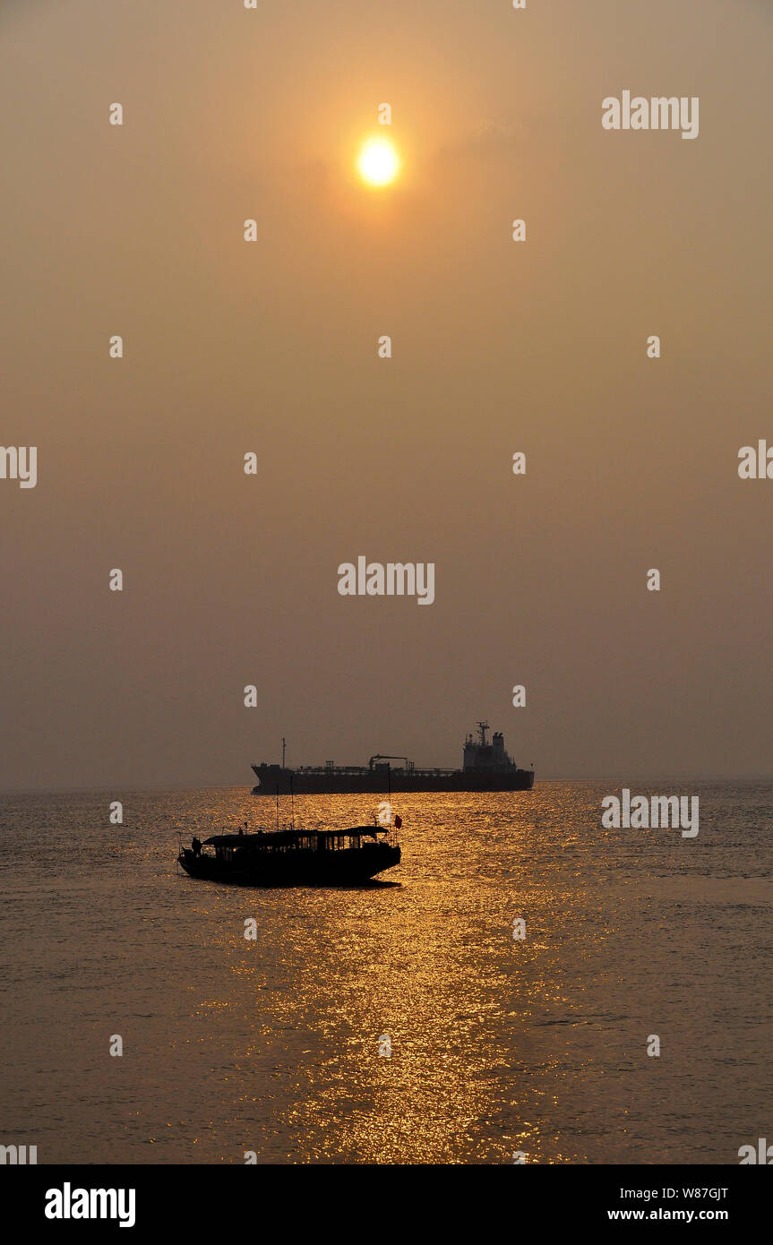 boats navigate the Yangtse river in China at sunset Stock Photo