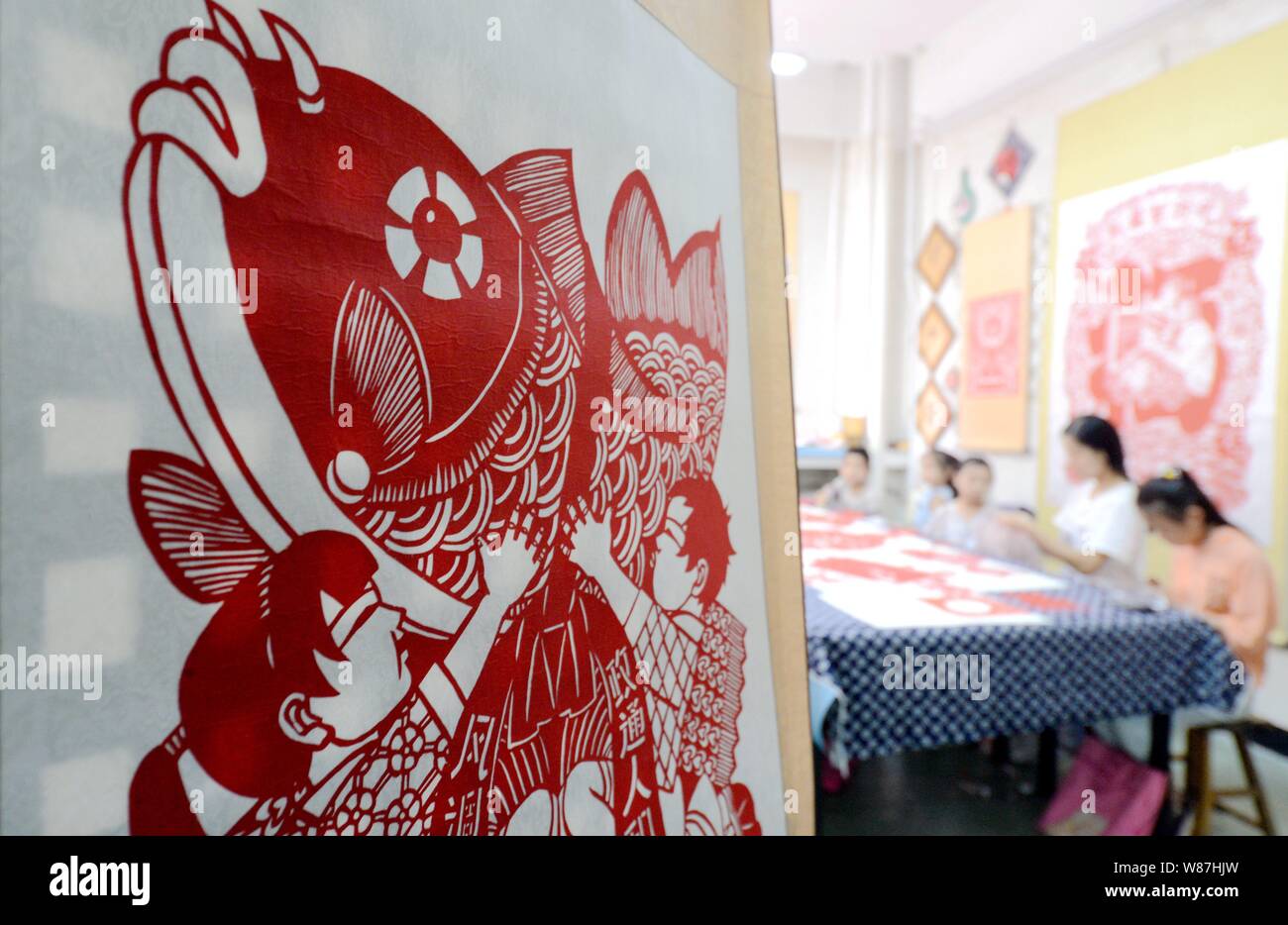 Shijiazhuang, China's Hebei Province. 8th Aug, 2019. Paper cutting artist Yin Lingling (2nd R) demonstrates techniques to children in Cixian County, north China's Hebei Province, Aug. 8, 2019. Yin offers free paper cutting class to local children during their summer vacation. Credit: Wang Xiao/Xinhua/Alamy Live News Stock Photo