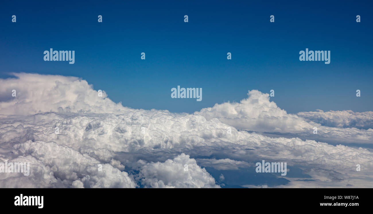 Cloudscape background. Blue sky and fluffy clouds Aerial view out of an ...