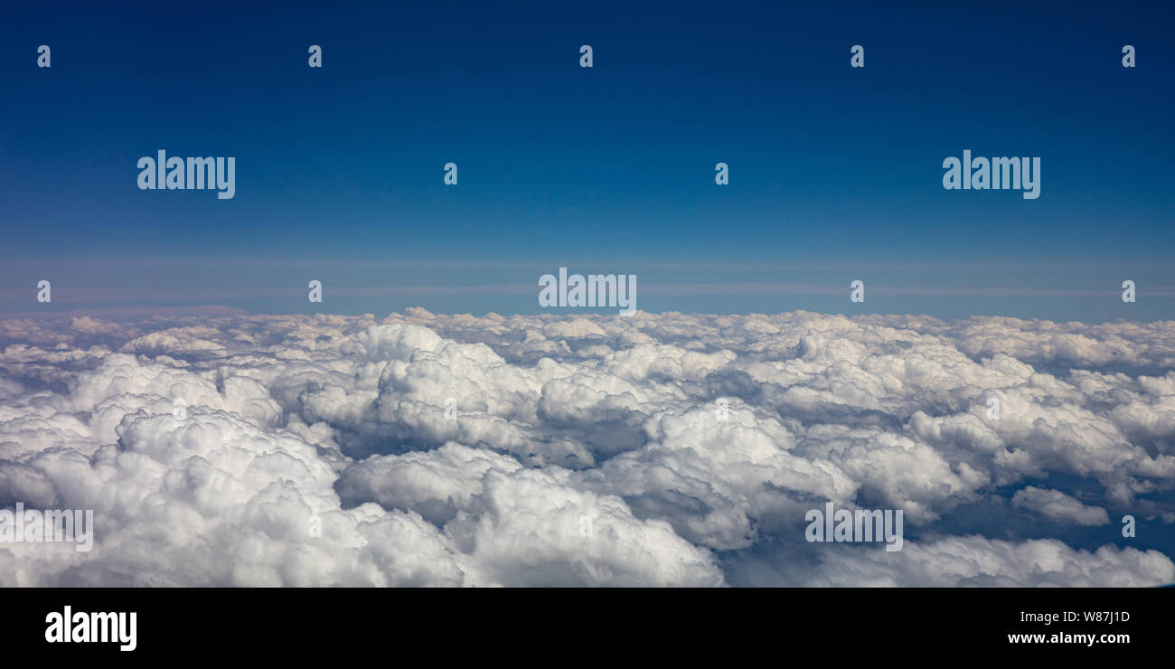 Cloudscape background. Blue sky and fluffy clouds Aerial view out of an ...