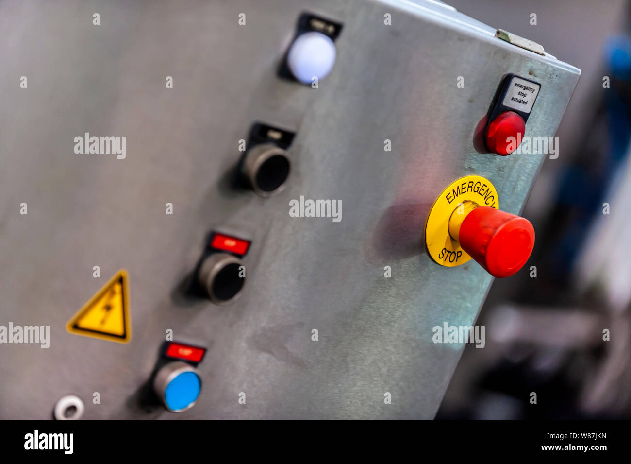 A control panel with an red Emergency Stop bitton in a brewery manufacturing plant Stock Photo