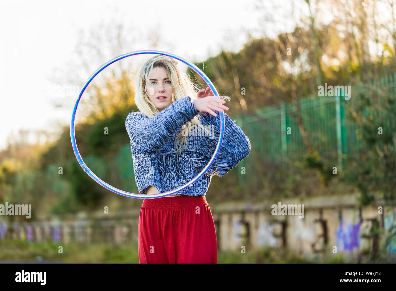 Girl looks through a hoop, directly to the camera, three quarter length. Stock Photo
