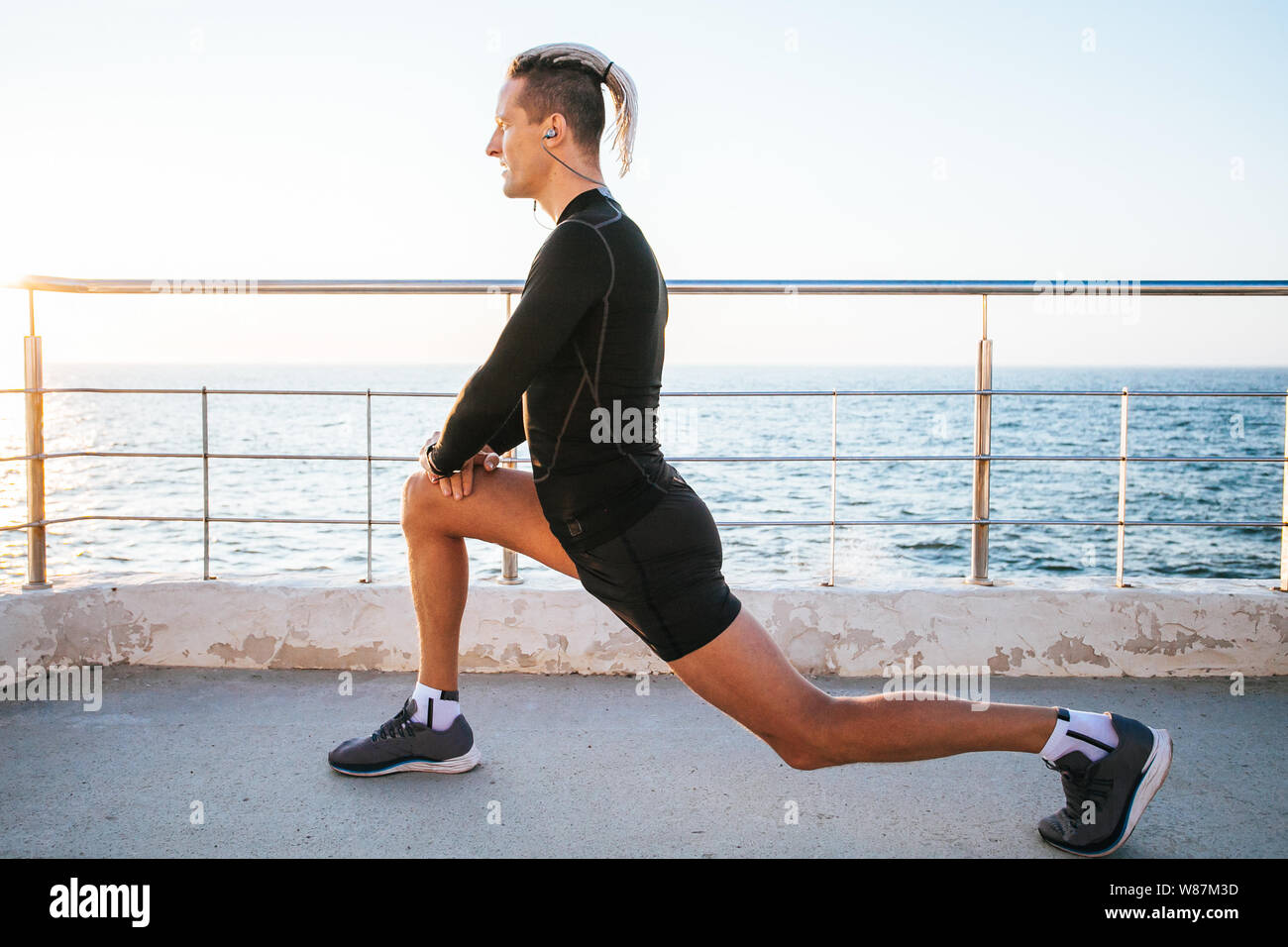 man stretching on the street. Runner on the city. Stock Photo