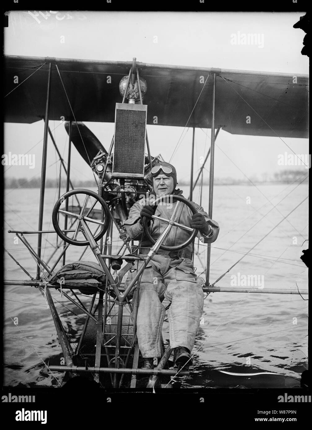 Commander H.C. Richardson, Curtiss seaplane; The good old days of aviation. Commander H.C. Richardson, crack U.S. Navy flyer, at the controls of a 1915 model Curtiss seaplane which he took on its maiden flight today on the Potomac at Washington. The old plane was discovered in storage at the Washington Navy Yard where it has been for over 12 years. Commander Richardson is testing the old boat to compare its behavior to that of craft of modern construction Stock Photo