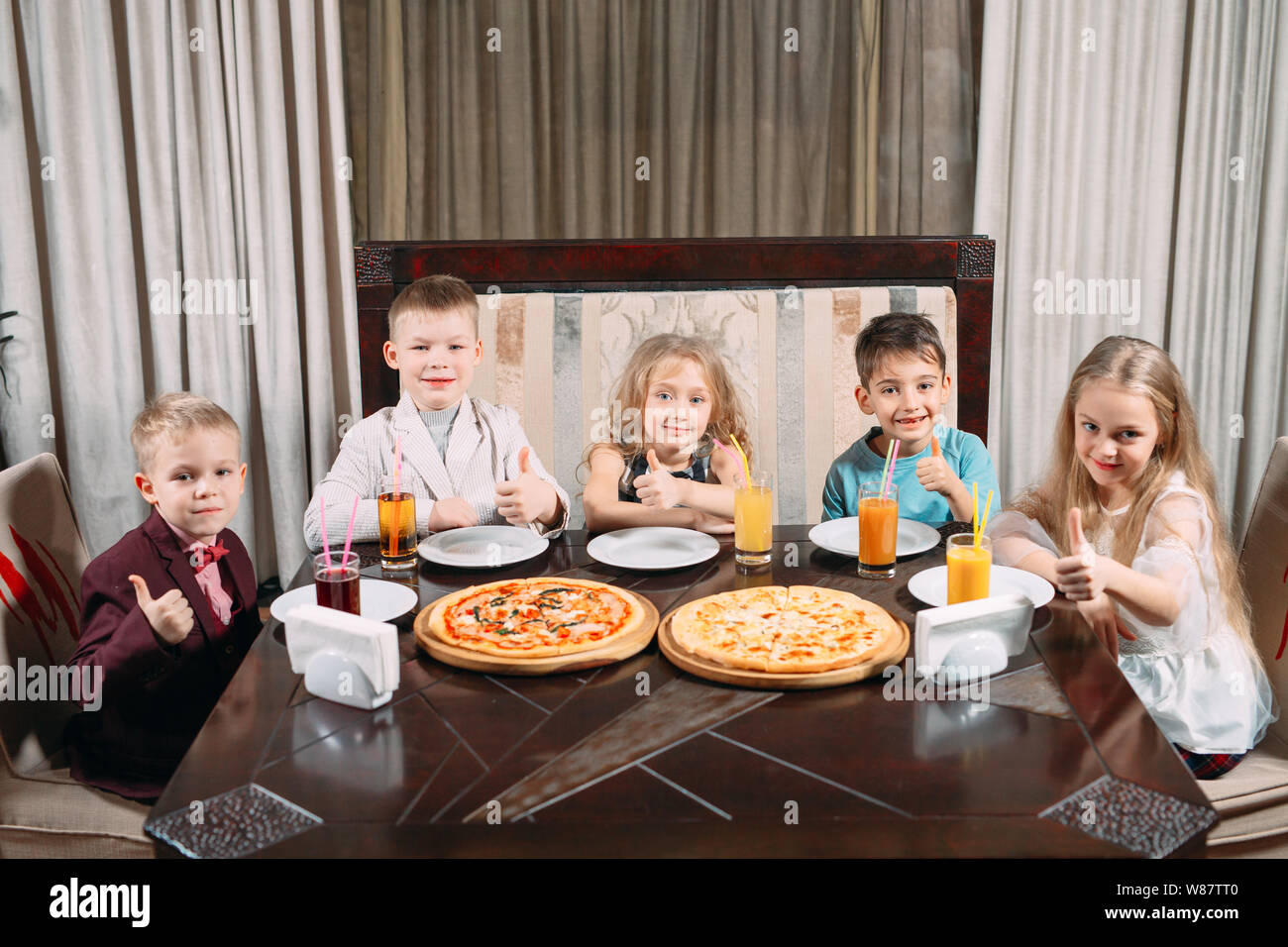 lovely children eat pizza in the restaurant Stock Photo