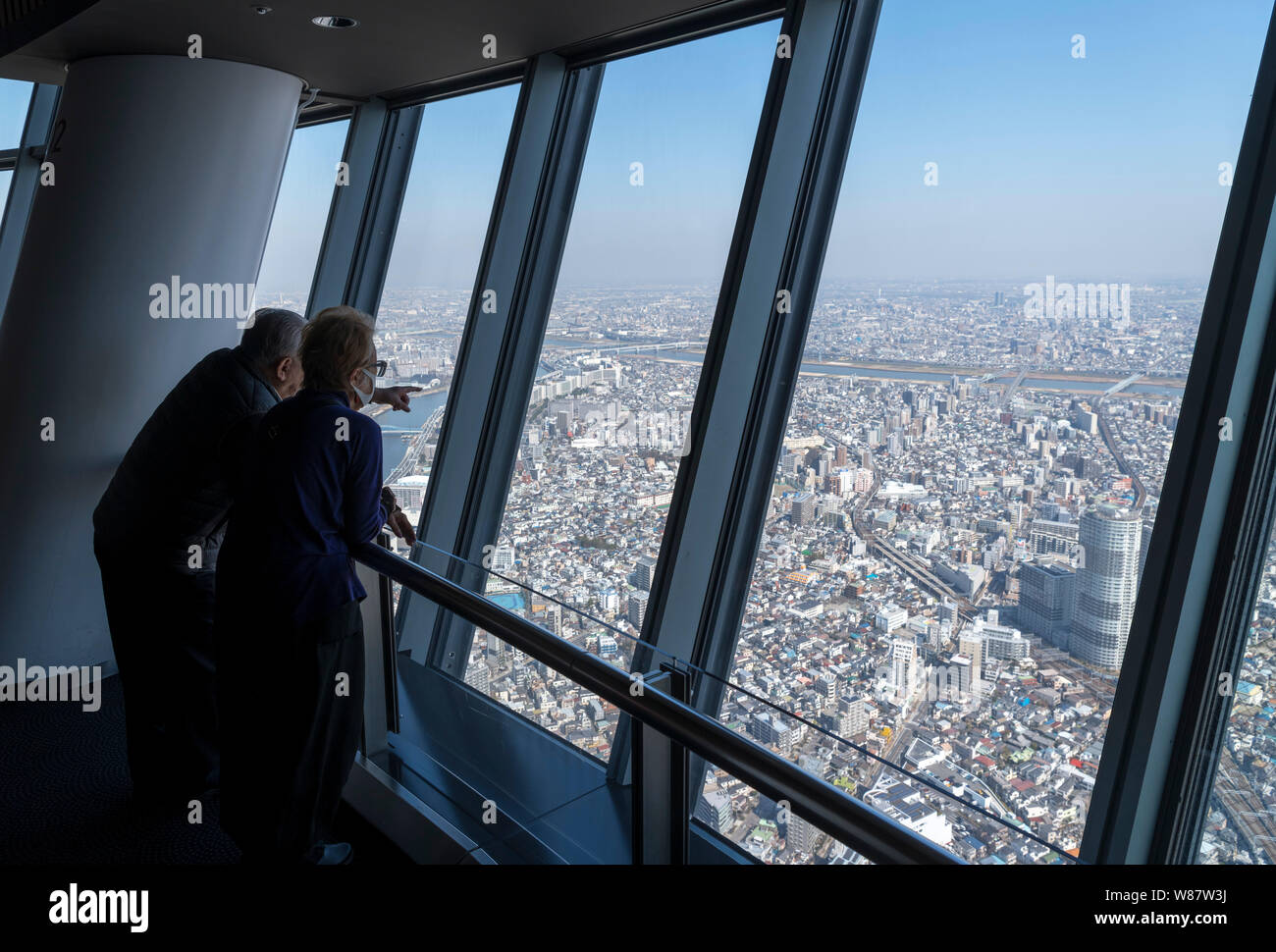 Elderly Japanese couple looking at the view over the city from the observation deck of the Tokyo Skytree,Tokyo, Japan Stock Photo