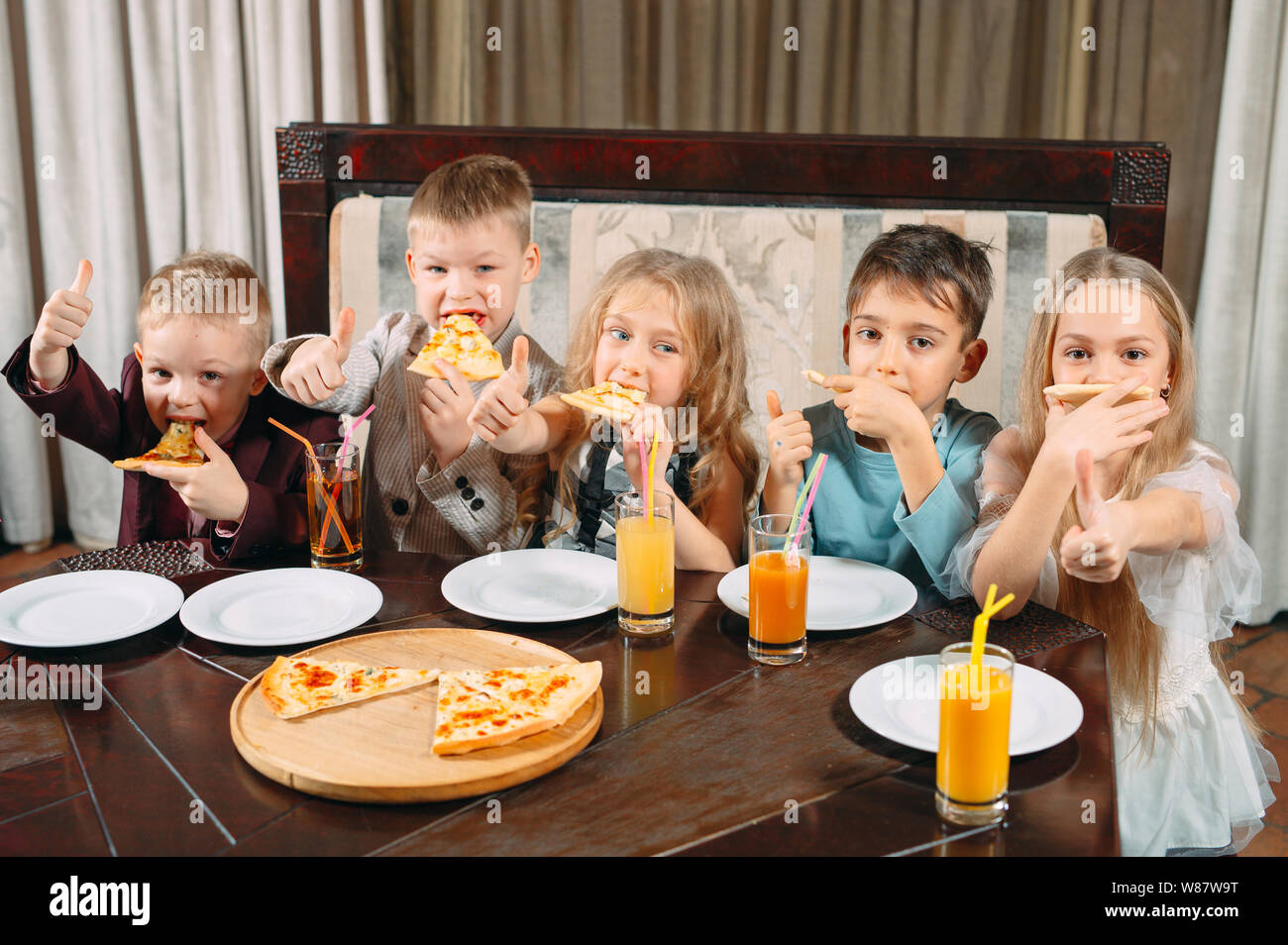 lovely children eat pizza in the restaurant Stock Photo