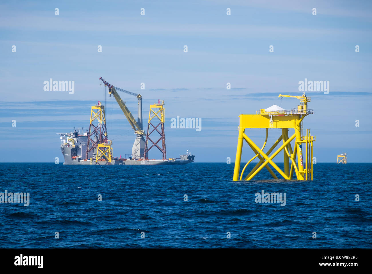 East Anglia ONE Offshore Wind Farm during construction with the heavy-lift construction vessel, Boka Lift, lifting one of the jackets in place Stock Photo