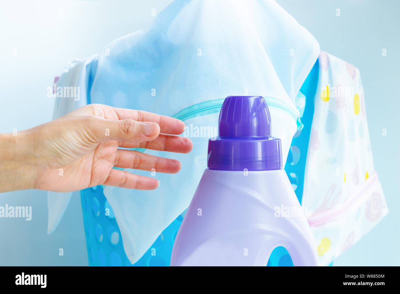 woman hand using liquid laundry softener detergent washing cloth Stock