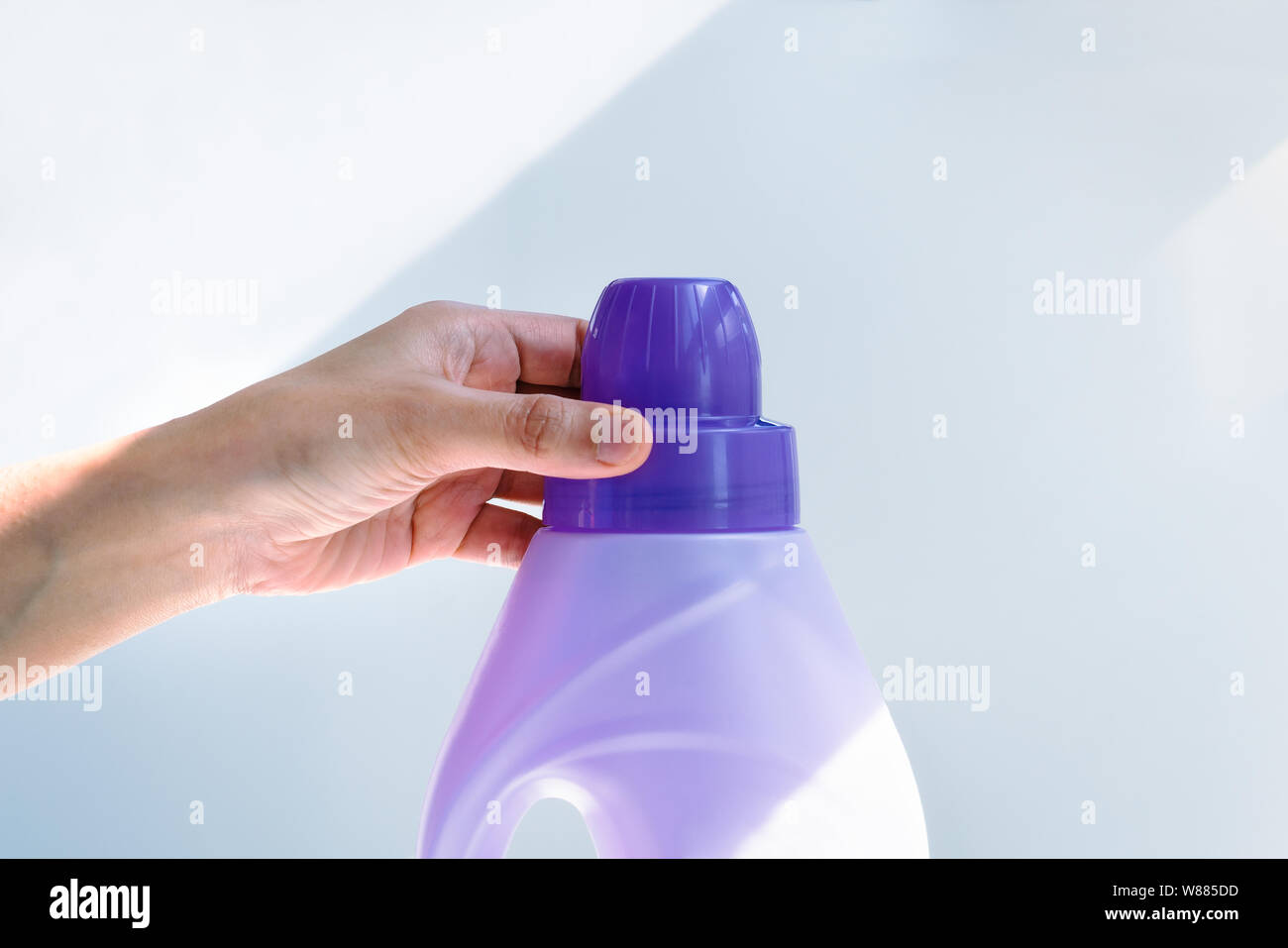 woman hand using liquid laundry softener detergent washing cloth Stock