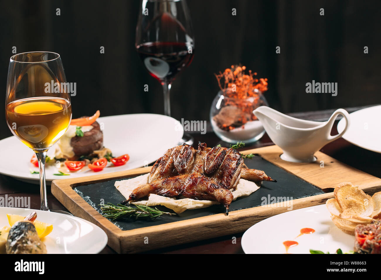 Grilled partridge, sea bass, Tartarus. Different dishes on the table in