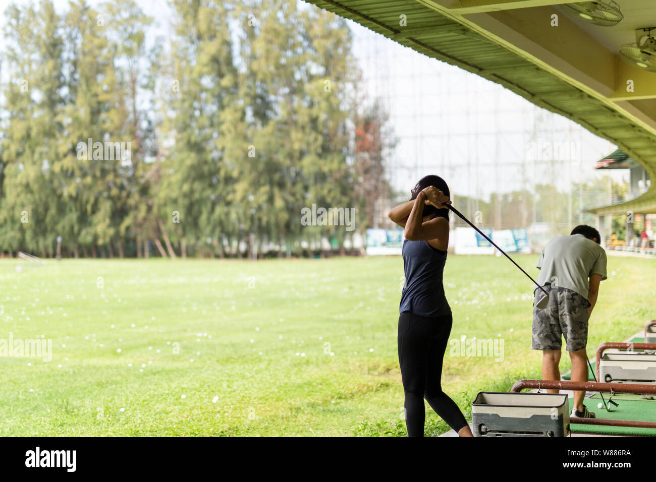 Asian woman practicing his golf swing at the golf driving range Stock