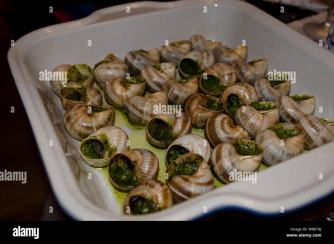 Escargots or snails in Garlic and Parsley Butter. Cooking traditional french escargots in garlic butter. Stock Photo